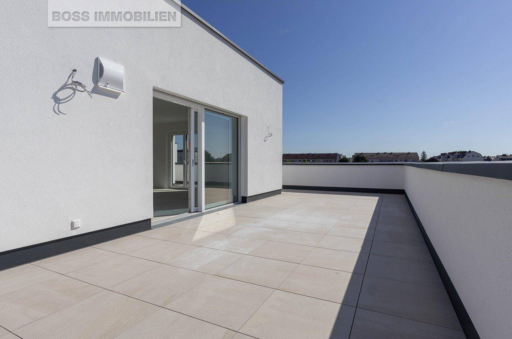 Geräumige, geflieste Dachterrasse mit viel Platz und Blick auf die Umgebung.
