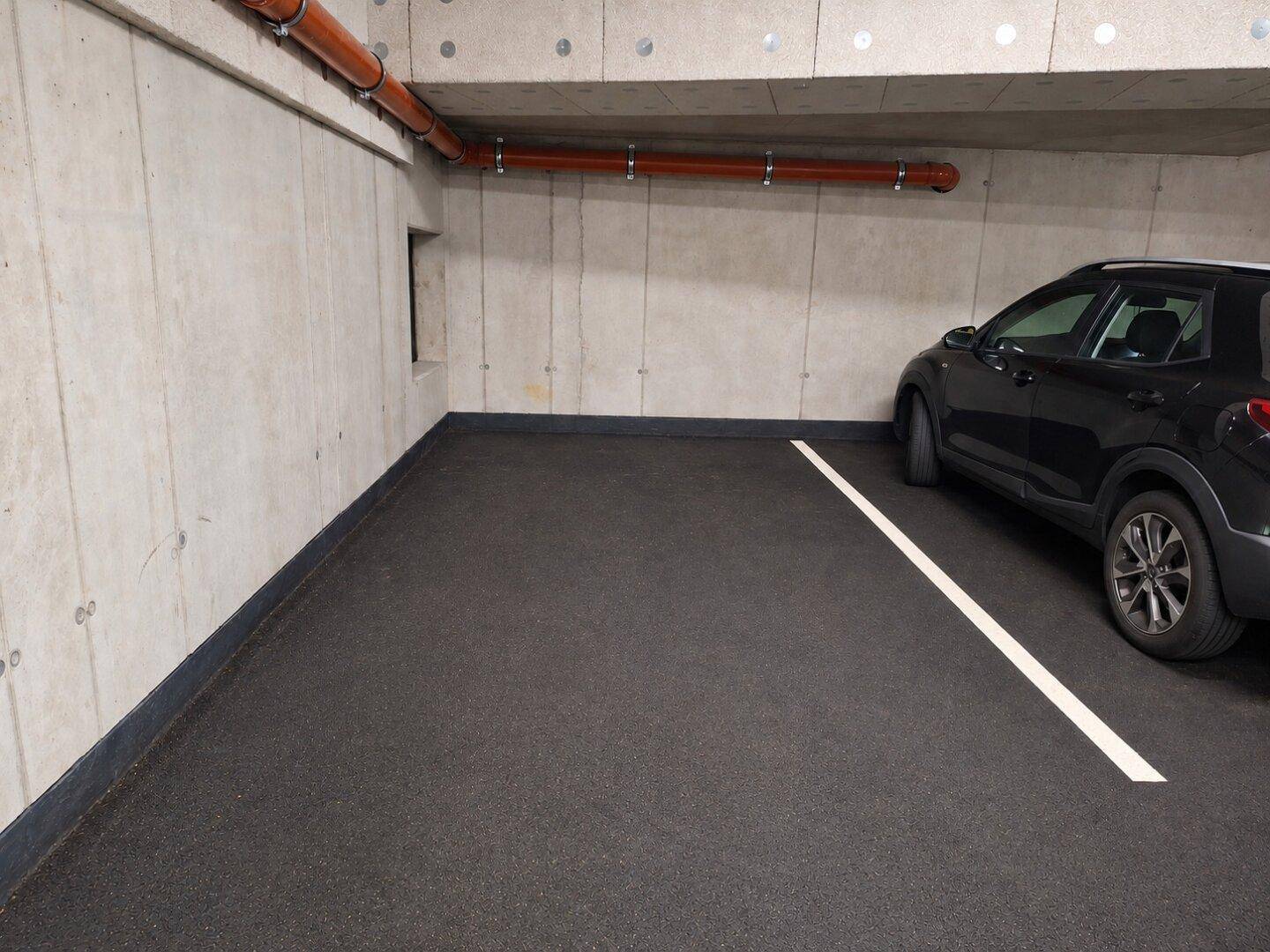 Einzelner Stellplatz in einer gepflegten Tiefgarage mit robusten Betonwänden und guter Beleuchtung.