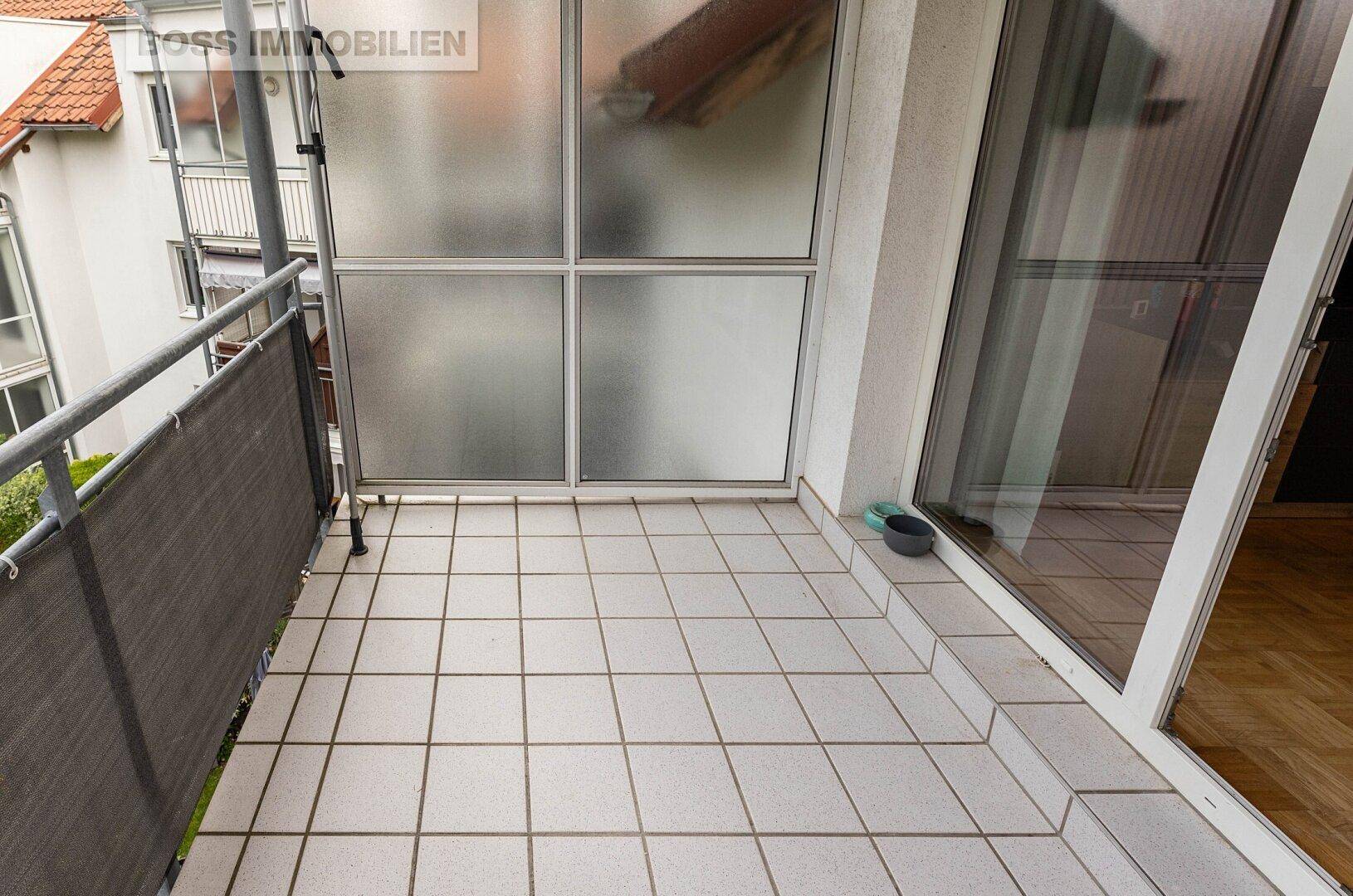 Gefliester Balkon mit Metallgeländer und Sichtschutz, ideal für entspannte Stunden im Freien.