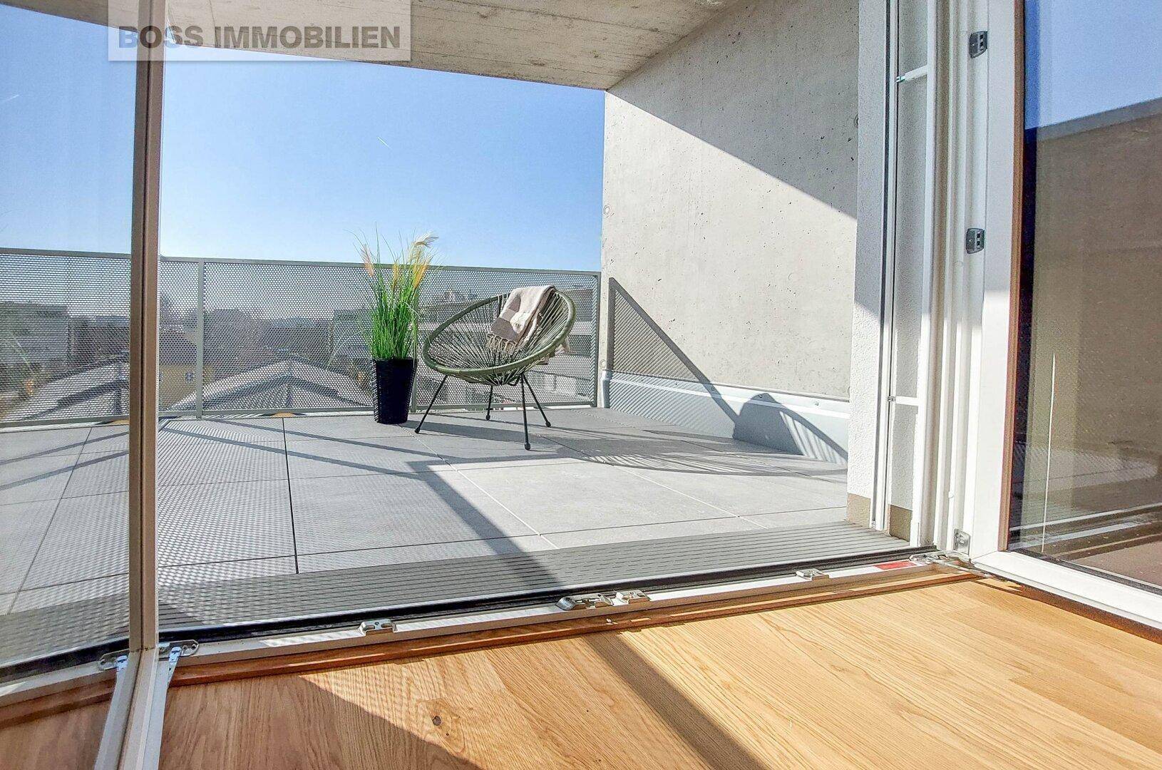 Geräumiger Balkon mit Sitzgelegenheit und Blick auf die Umgebung.