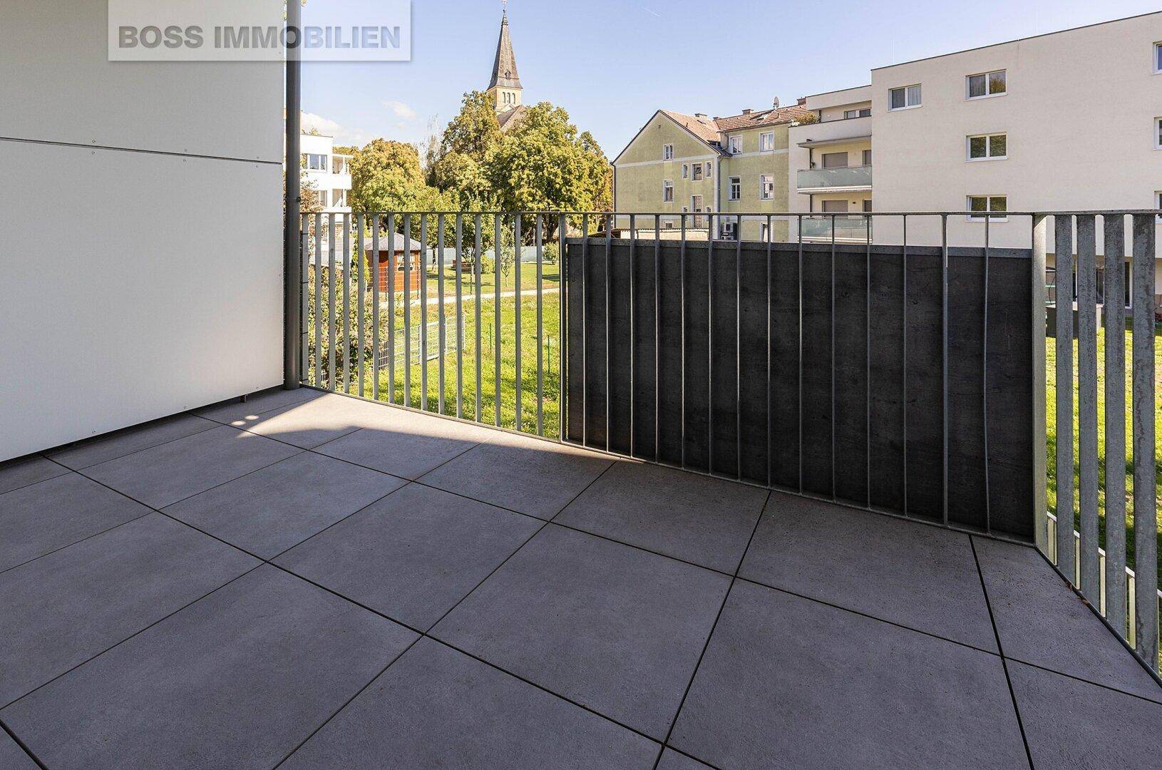 Geräumiger Balkon mit Fliesenboden und Metallgeländer, bietet Platz zum Entspannen.
