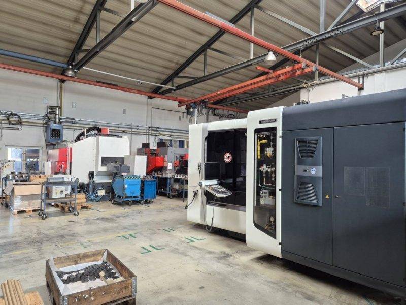 Industrielle Werkstatt mit mehreren großen Maschinen und Betonboden.
