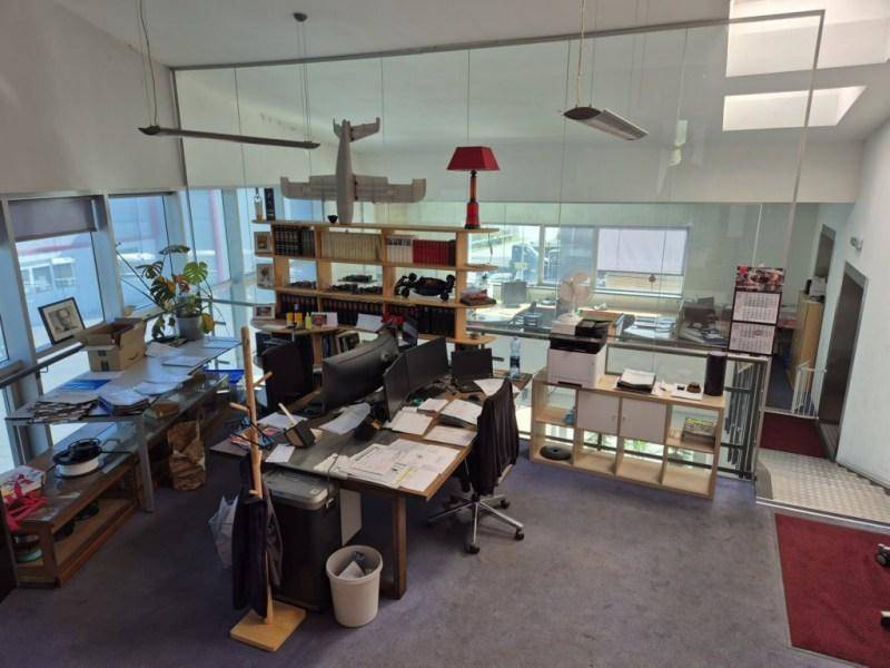 Offener Bürobereich auf einer Galerie mit Schreibtischen, Regalen und viel Tageslicht.