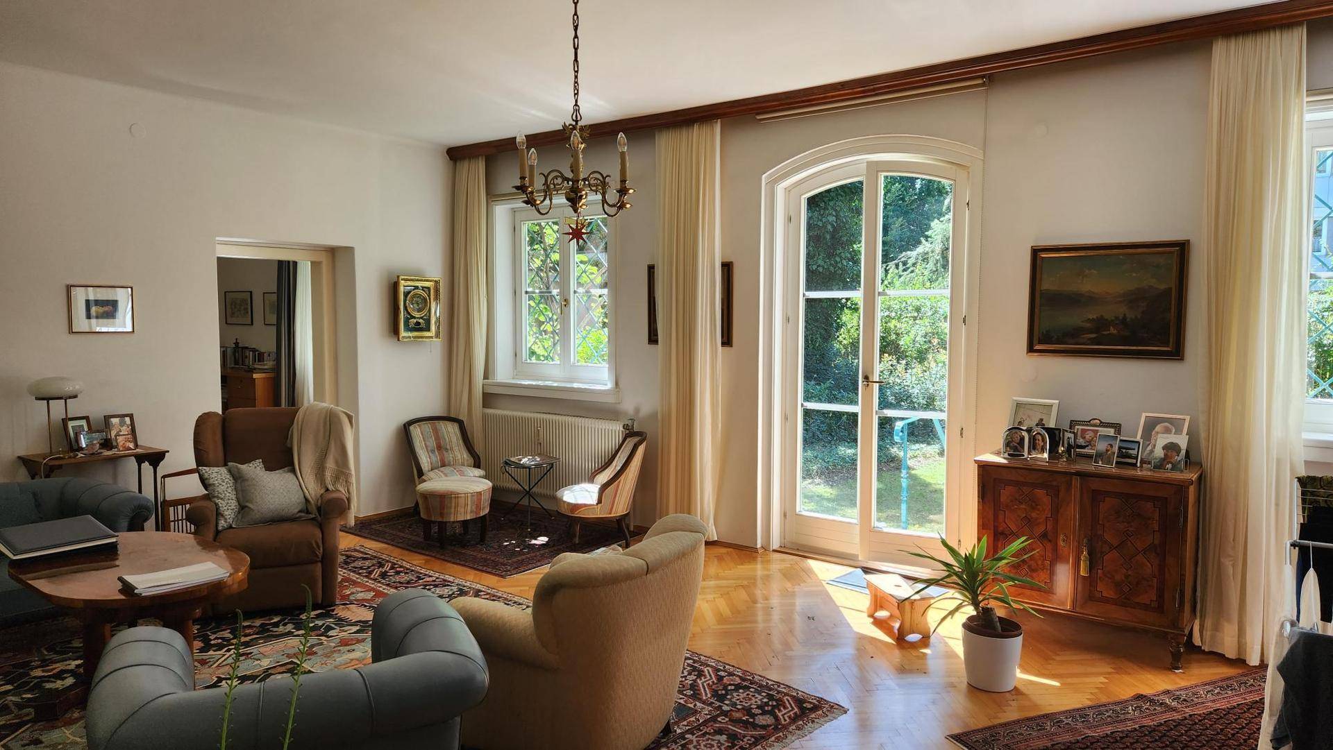 Geräumiges Wohnzimmer mit klassischem Interieur, Holzboden und viel Tageslicht.