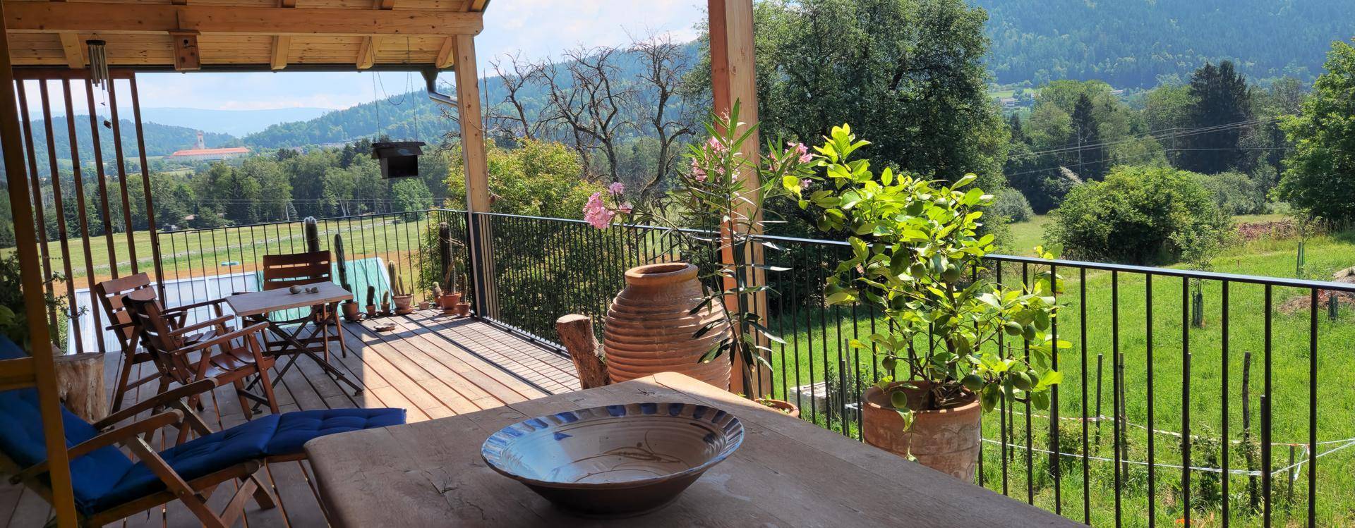 Gemütlicher Balkon mit Sitzgelegenheiten und weitem Blick über die grüne Landschaft.