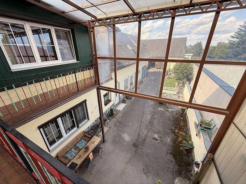 Blick vom verglasten Balkon auf den Innenhof und die umliegenden Gebäude.