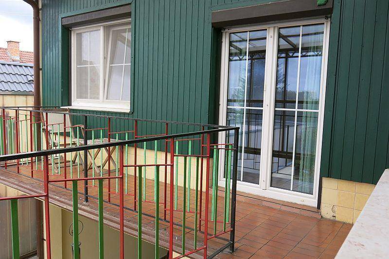 Kleiner Balkon mit Fliesenboden, Metallgeländer und Blick auf die Umgebung.