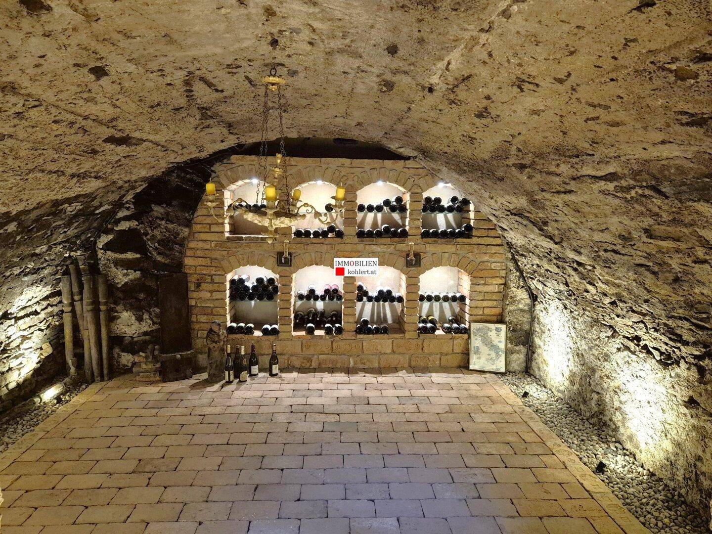 Historischer Weinkeller mit Ziegelgewölben, Steinwänden und Flaschenregalen.