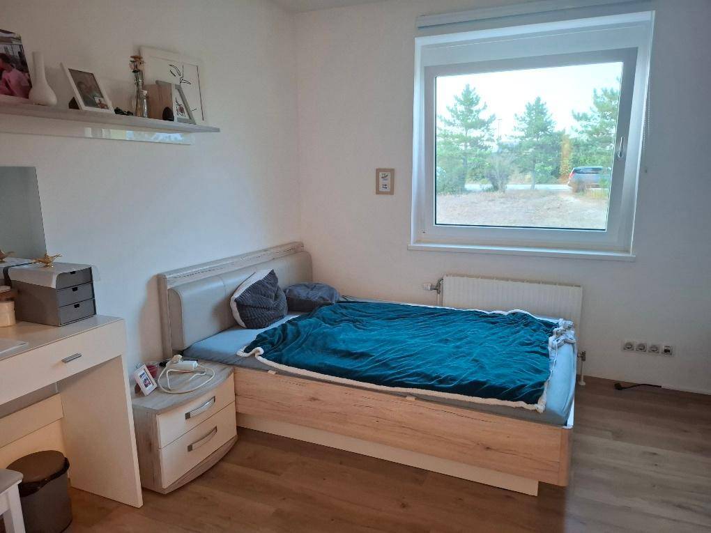 Helles Schlafzimmer mit Einzelbett, Schreibtisch und einem großen Fenster, das einen weiten Blick bietet.