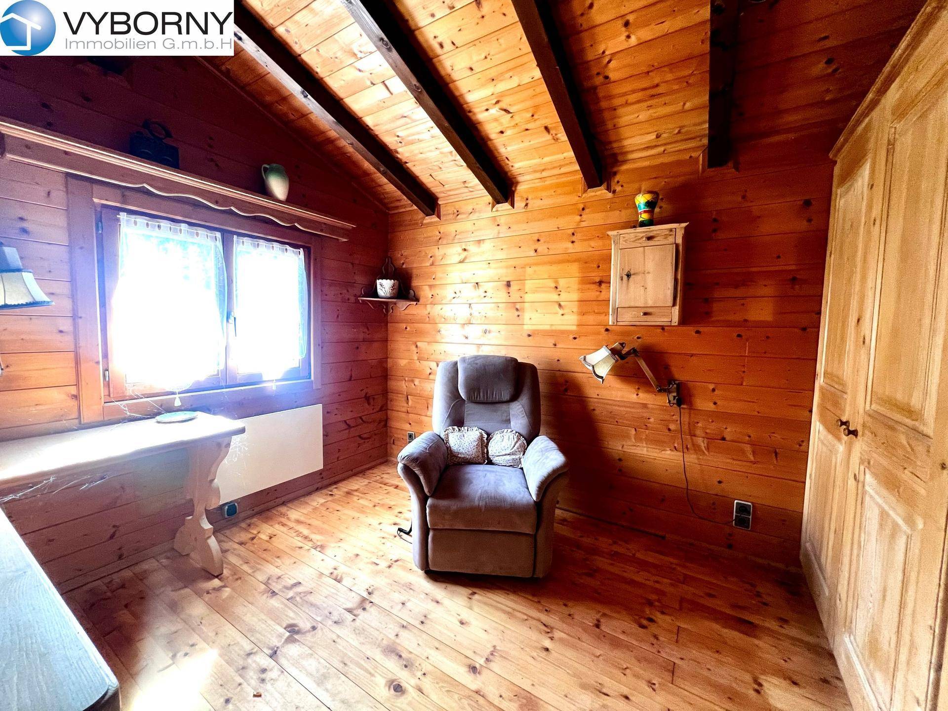 Schlafzimmer im rustikalen Stil mit Holzwänden, Holzboden und schrägen Decken.