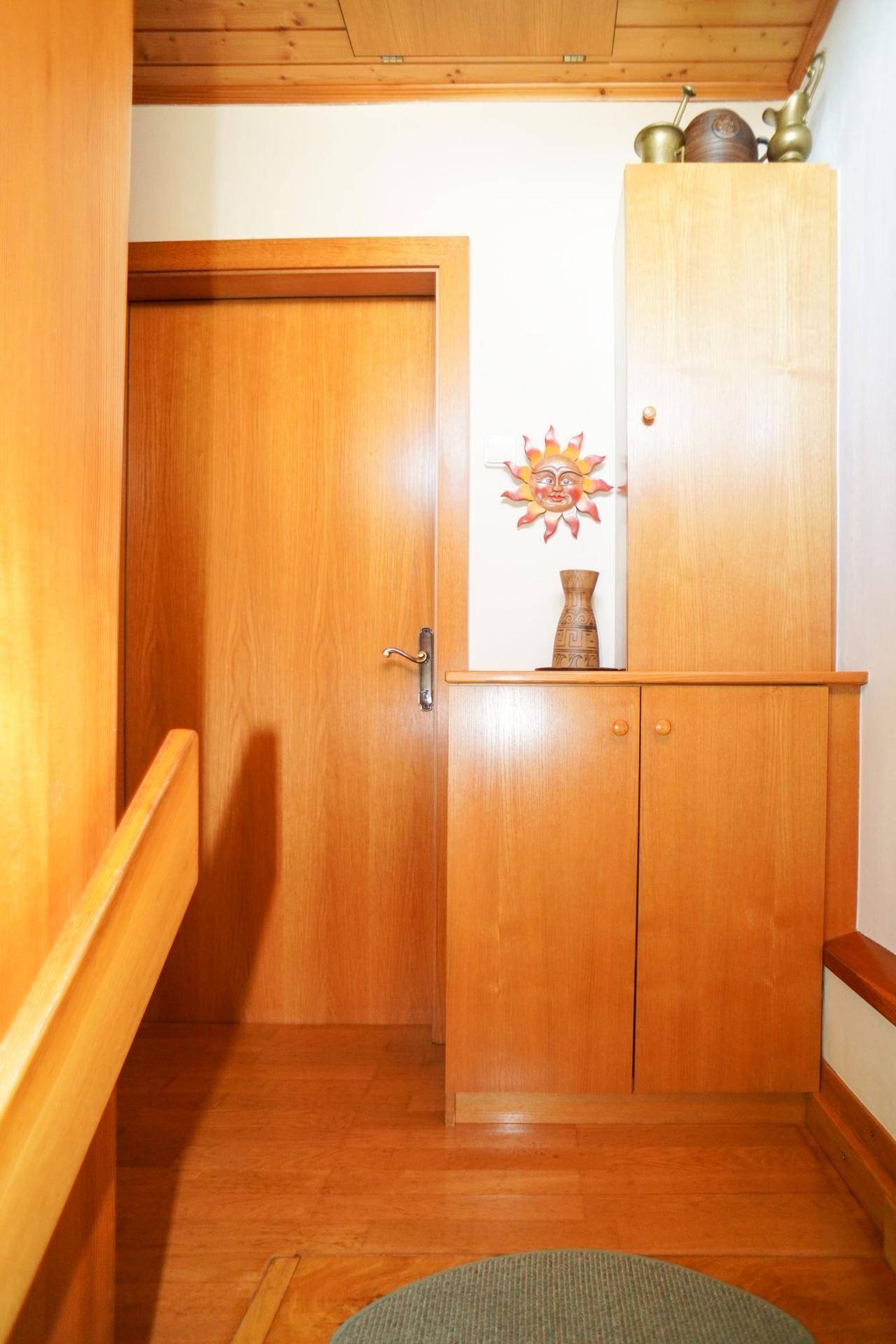 Heller Flur mit Holzmöbeln und Tür, die zu weiteren Räumen im Obergeschoss führt.