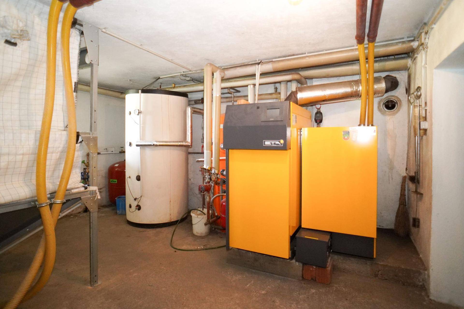 Heizungsraum im Keller mit zwei großen Heizkesseln und Rohrleitungen.