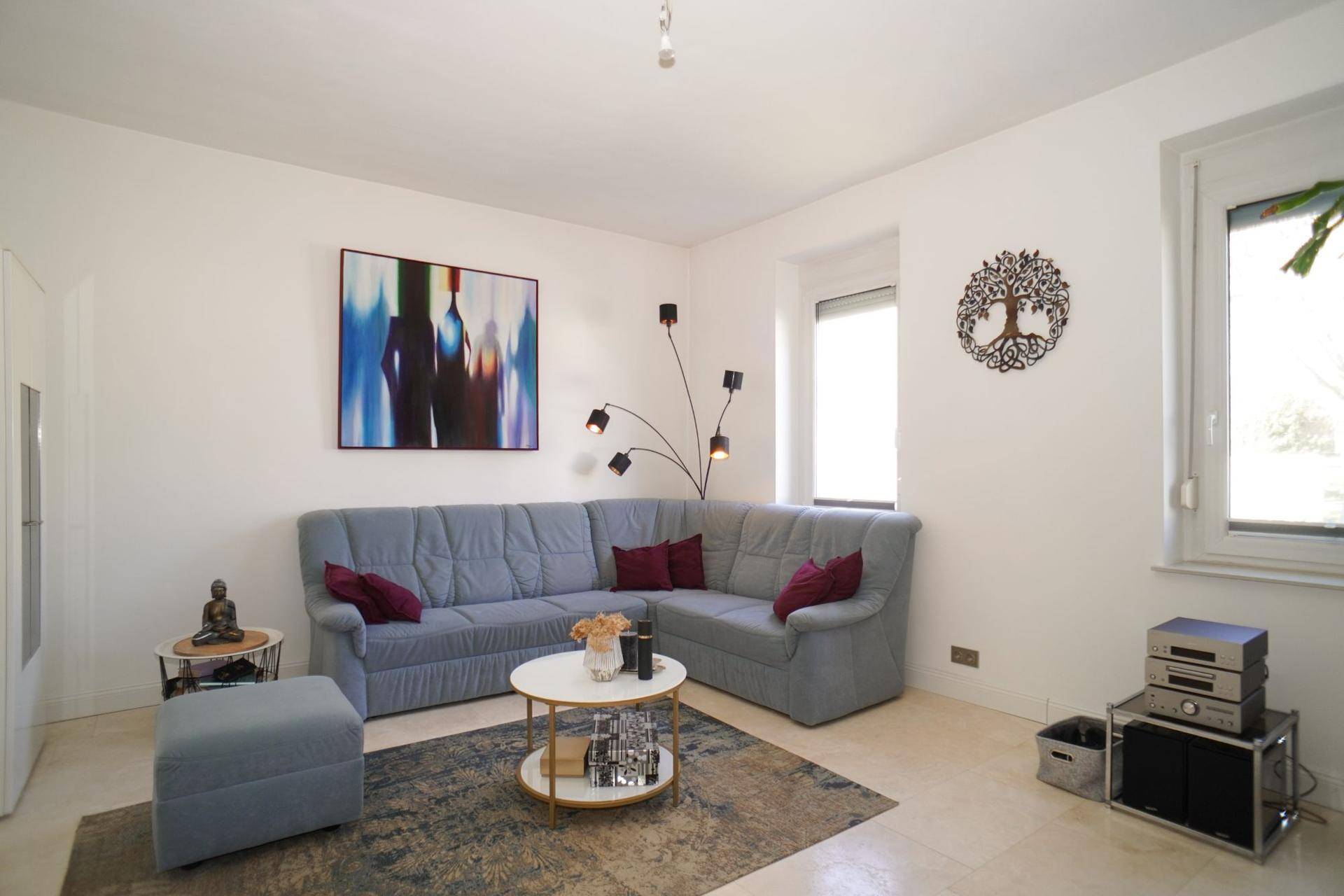 Gemütliches Wohnzimmer mit großem Ecksofa, modernem Teppich und viel natürlichem Licht.