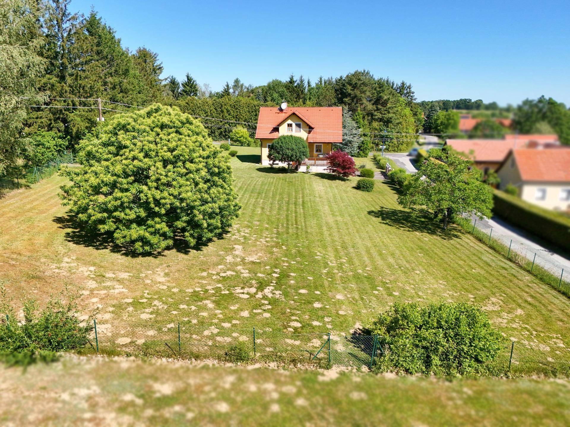 Weitläufiges Grundstück mit Einfamilienhaus und Blick auf die ländliche Umgebung.