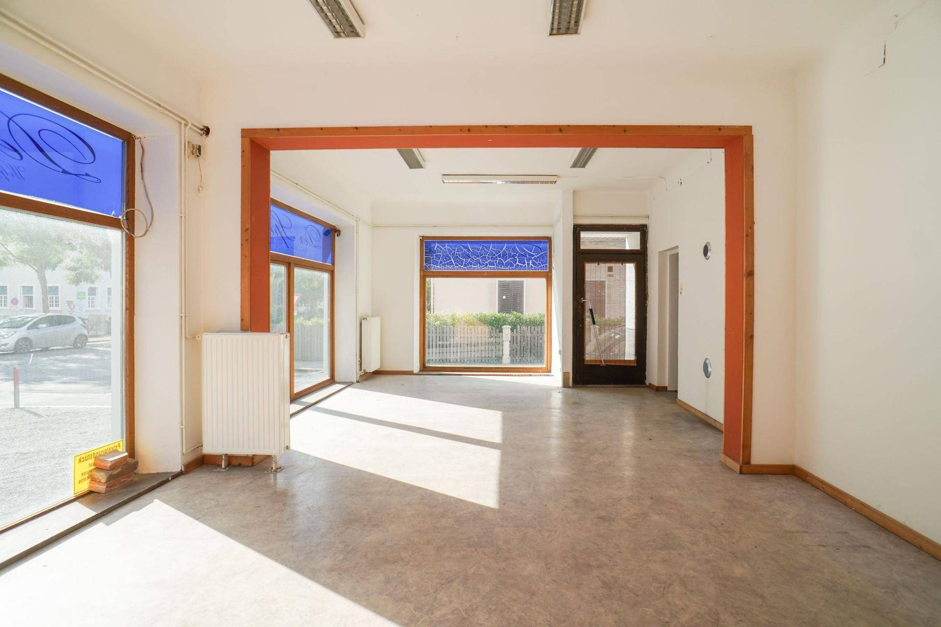 Geräumiger, heller Raum mit großen Fenstern und Heizkörpern, ideal für eine flexible Nutzung.