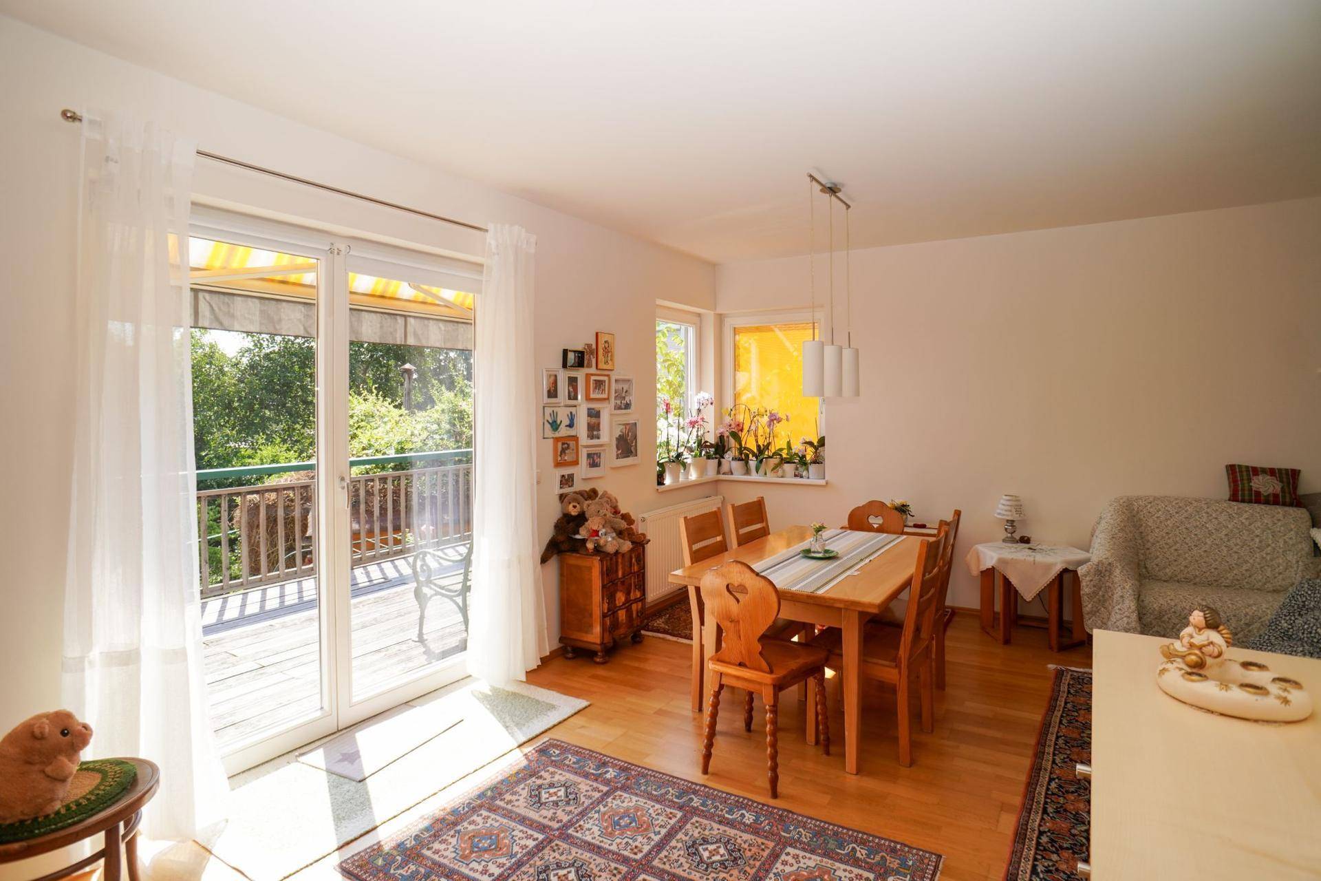 Heller Wohn- und Essbereich mit Holzboden, Esstisch und direktem Zugang zur Terrasse.