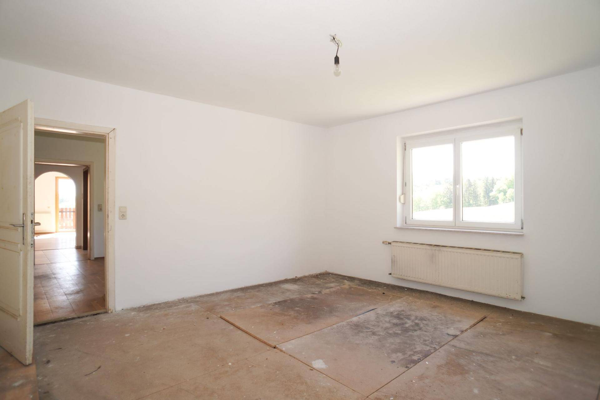 Raum mit unfertigem Bodenbelag und Fenster, bereit für die individuelle Gestaltung.