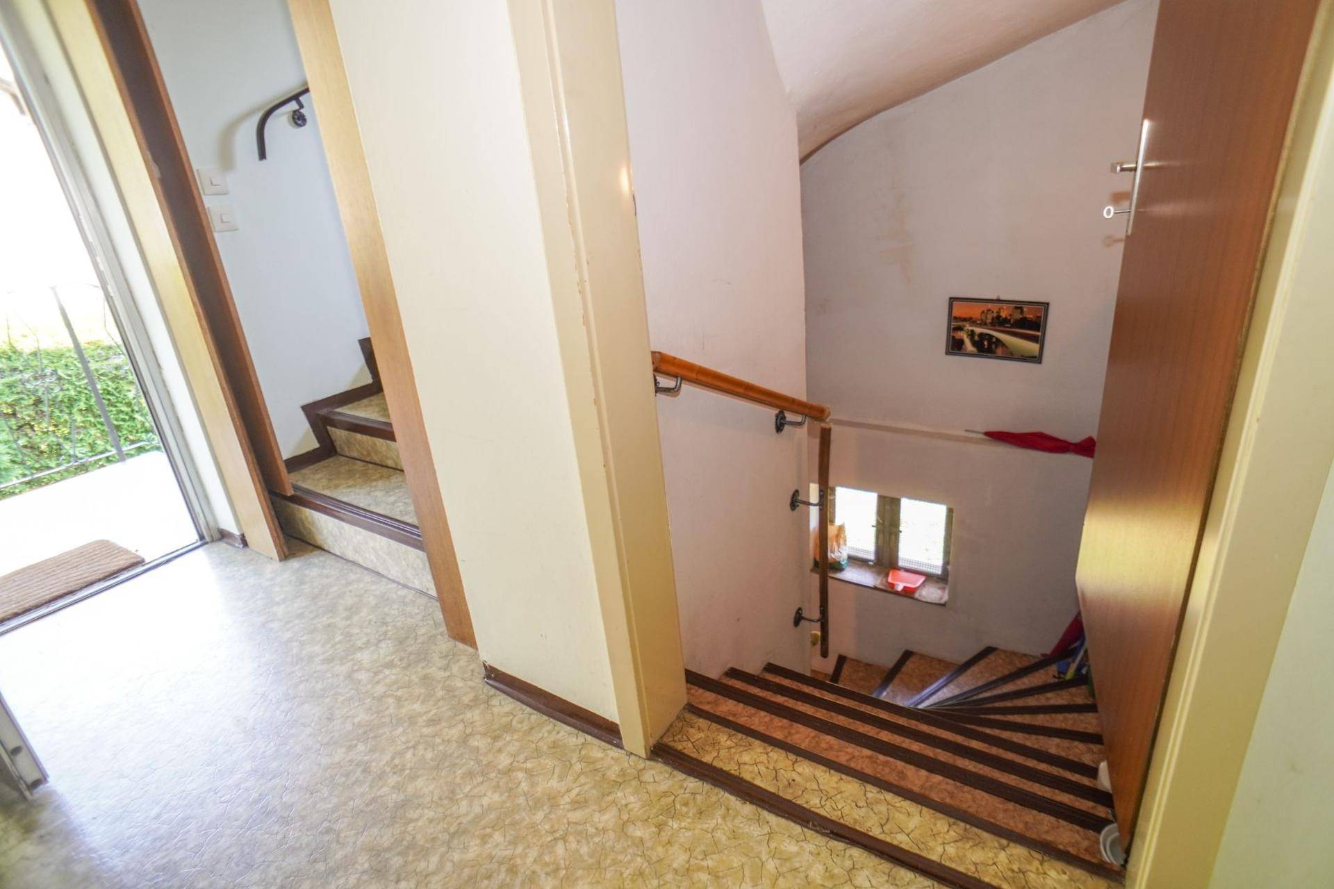 Treppenhaus mit Holzhandlauf und Fenster, das die verschiedenen Ebenen des Hauses verbindet.