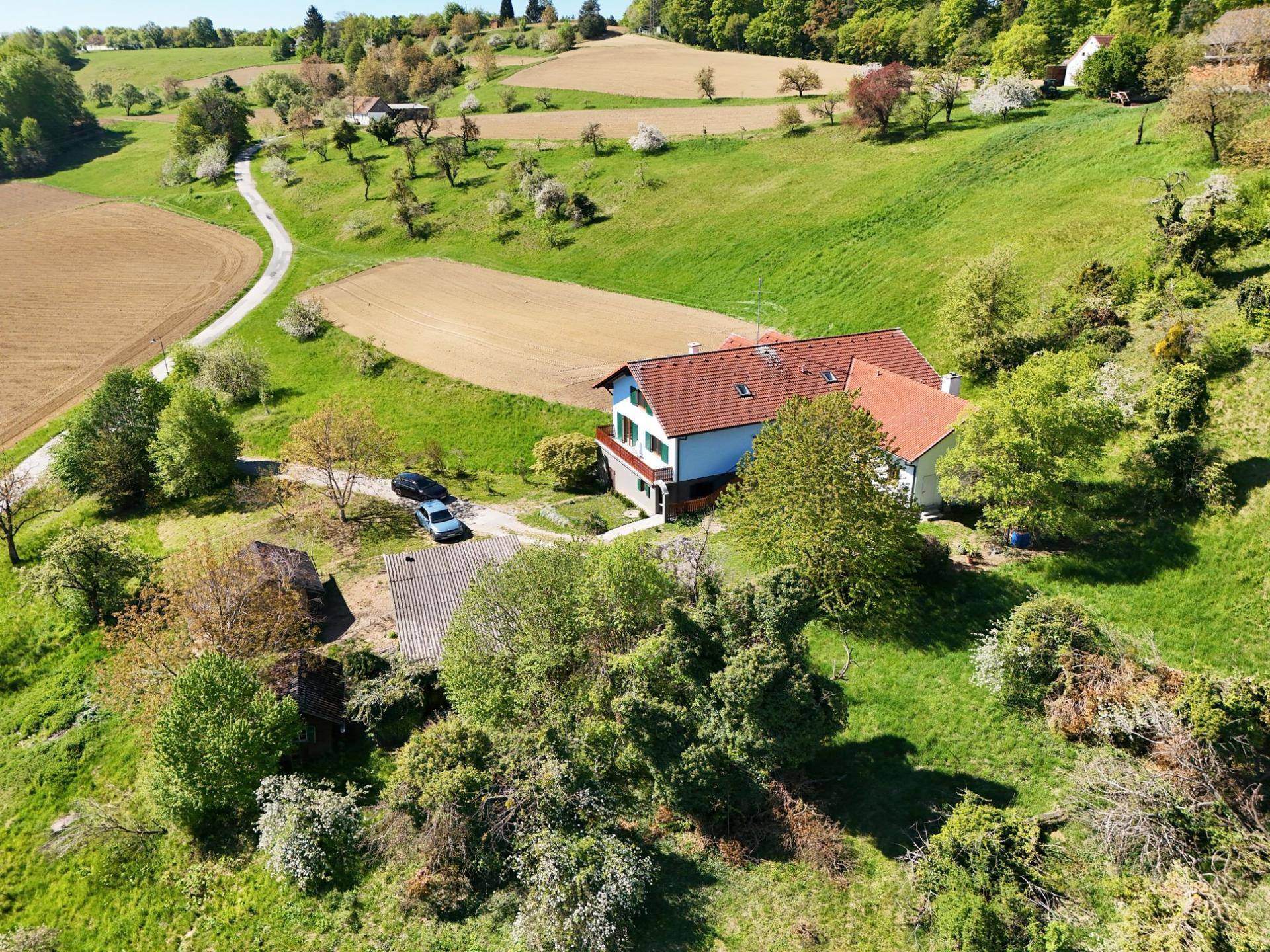 Weitläufige Luftaufnahme eines Anwesens mit Haus und Nebengebäuden in ländlicher Umgebung.