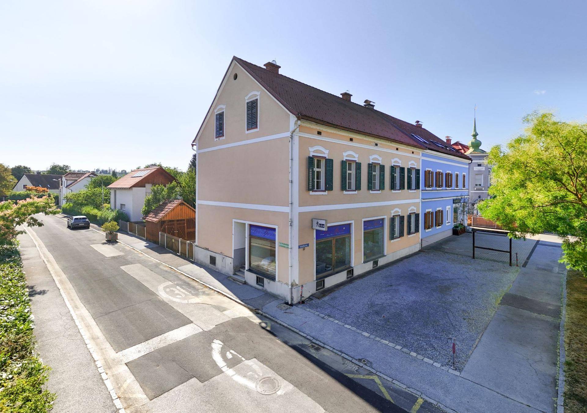Luftaufnahme des Anwesens mit Hauptgebäude, Garten und umliegender Nachbarschaft.
