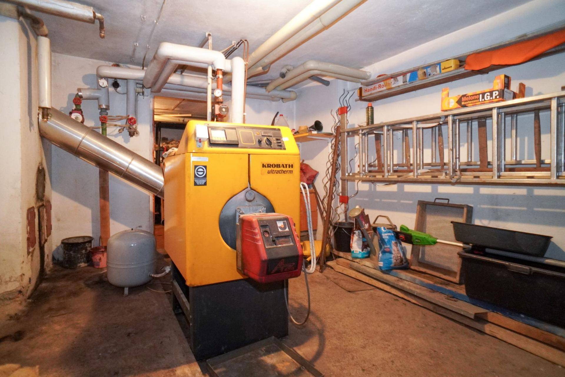 Heizungsraum im Keller mit moderner Heizungsanlage und Lagerflächen.