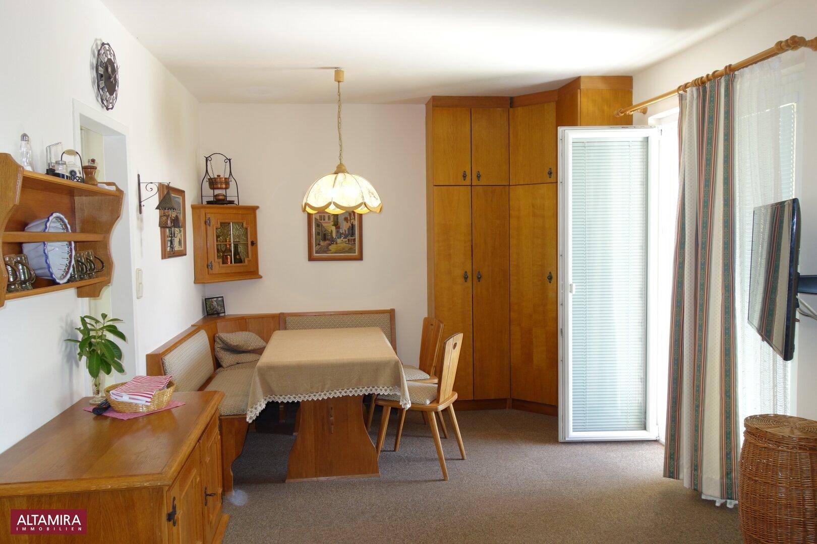 Gemütlicher Essbereich mit Eckbank, Holztisch und praktischen Einbauschränken.