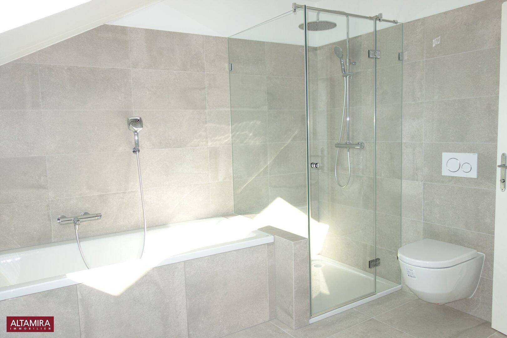 Helles Badezimmer mit Badewanne, moderner begehbarer Dusche und wandhängendem WC.