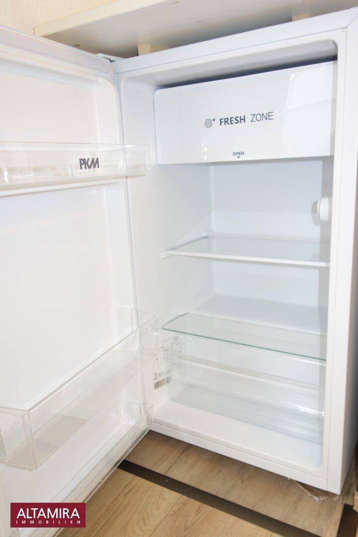 Offener Kühlschrank mit praktischen Glasablagen und einem speziellen "Fresh Zone" Fach.