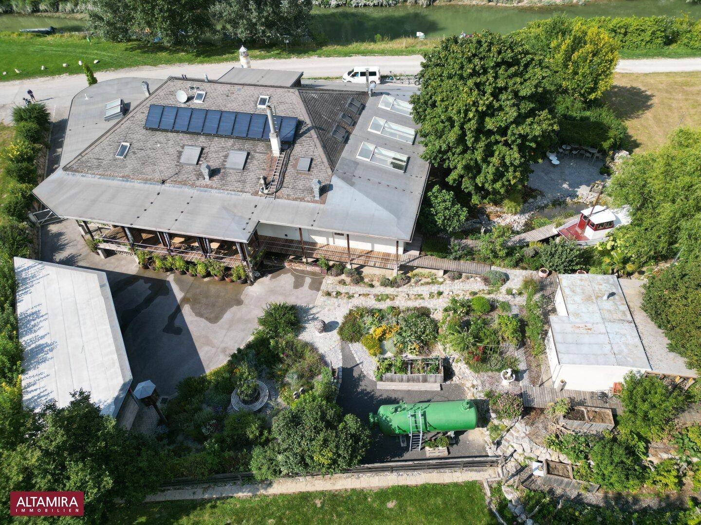 Luftaufnahme des Anwesens mit Solaranlage auf dem Dach und weitläufiger Gartenlandschaft.
