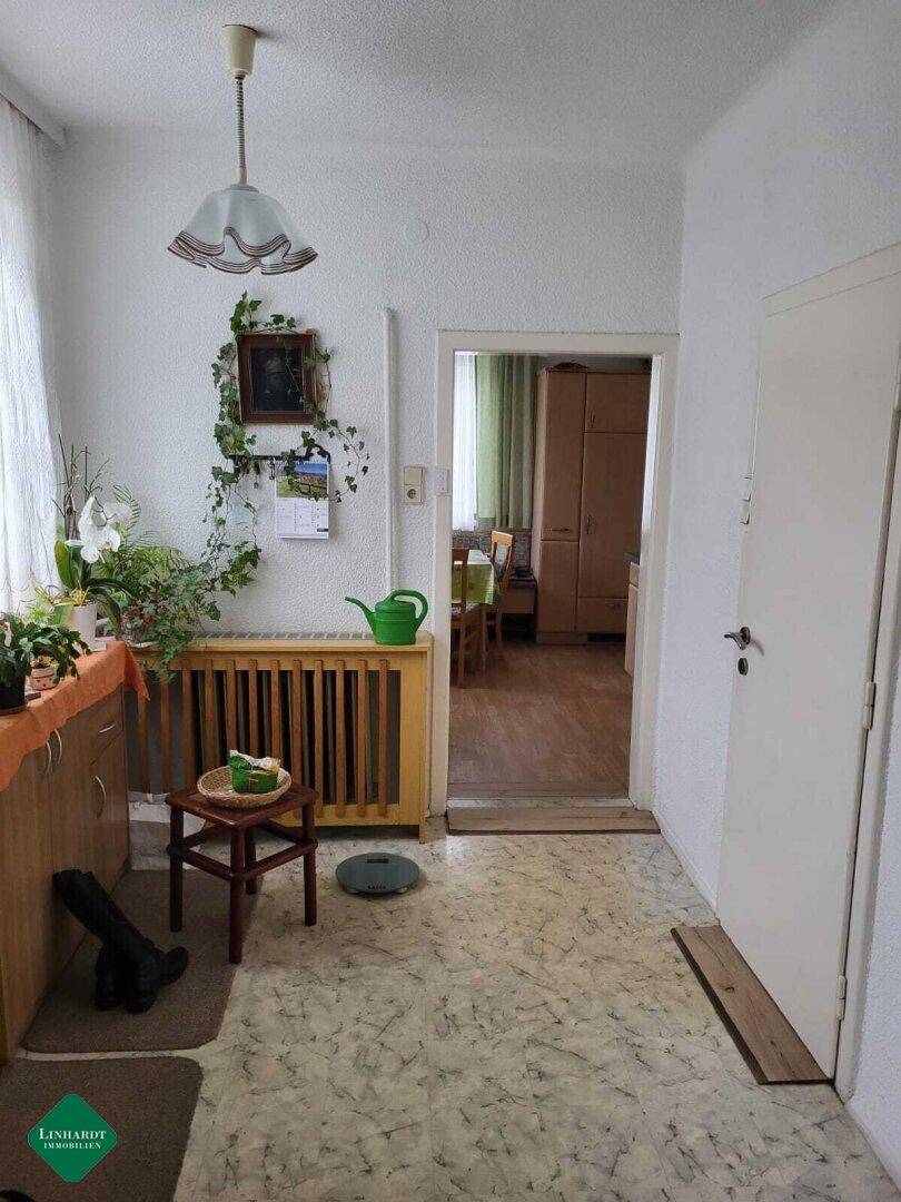 Heller Flur mit gemustertem Boden, Heizkörperverkleidung und Zugang zu weiteren Räumen.