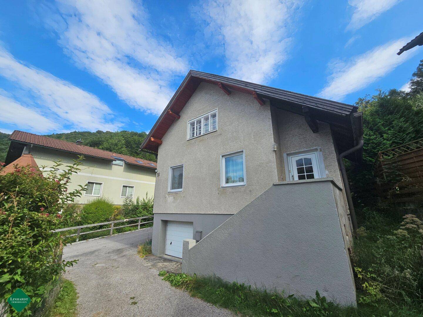 Ansicht des Wohnhauses von der Seite mit Garage und Zugang zum oberen Stockwerk.