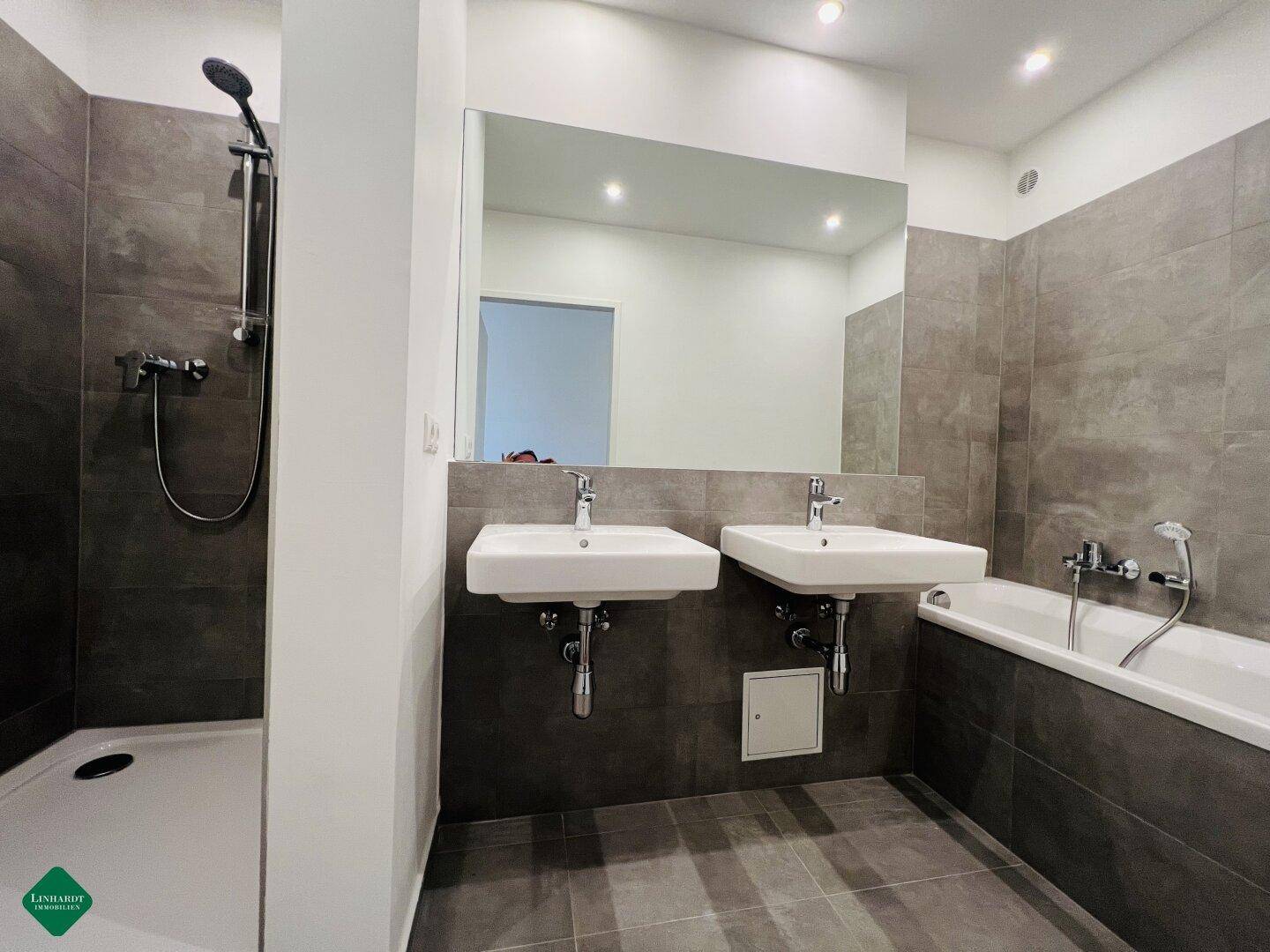 Modernes Badezimmer mit Doppelwaschbecken, geräumiger Dusche und Badewanne.