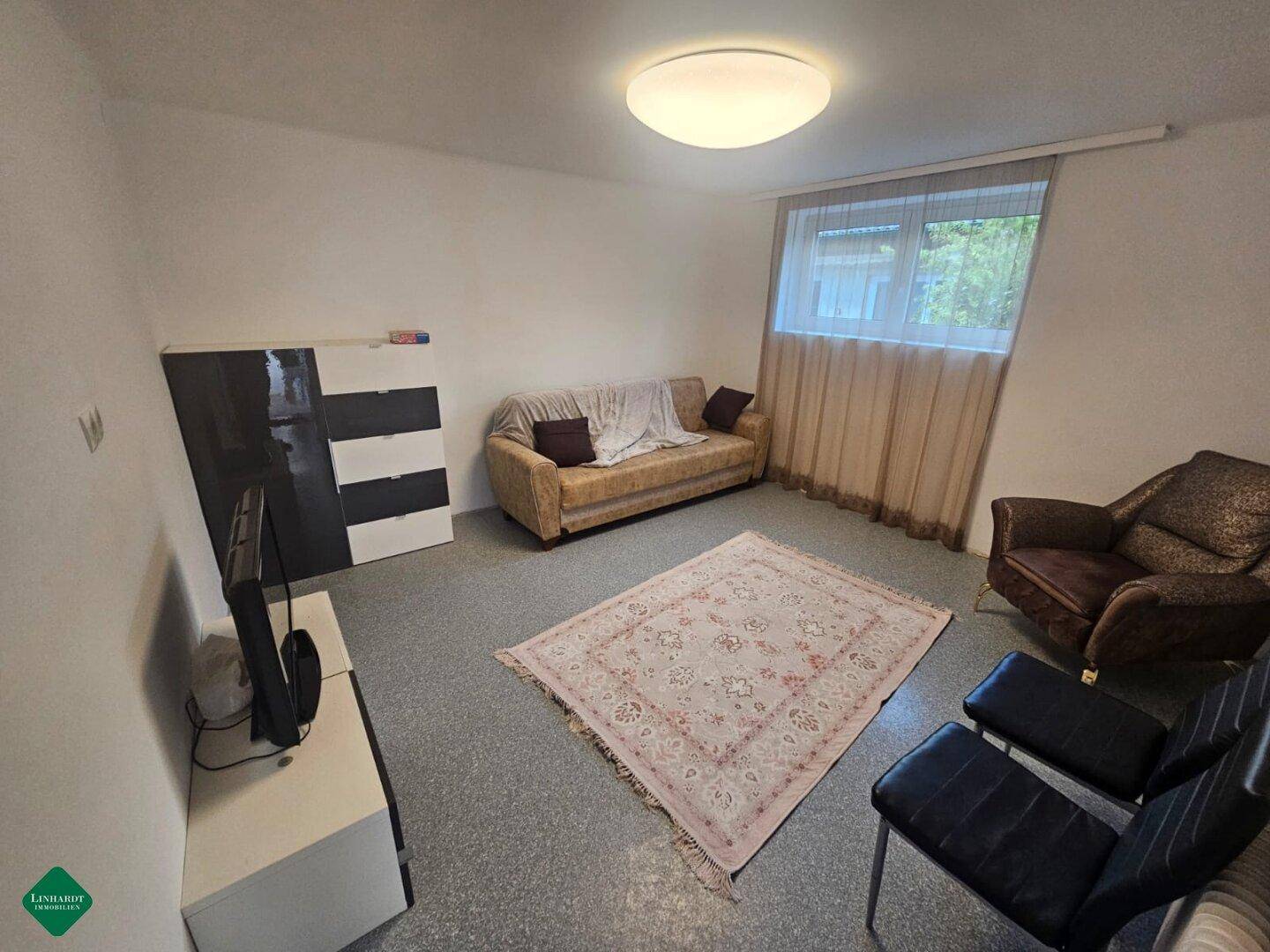 Schlafzimmer mit Sofa, Teppich und Schrank, bietet zusätzlichen Wohnraum.