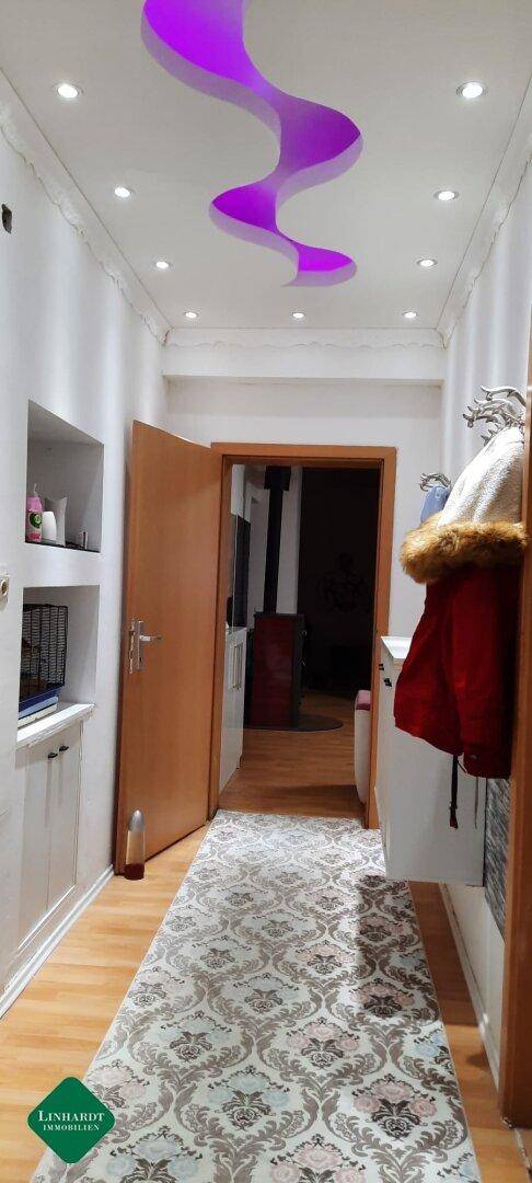 Heller Flur mit modernem Lichtdesign an der Decke und Holzfußboden.