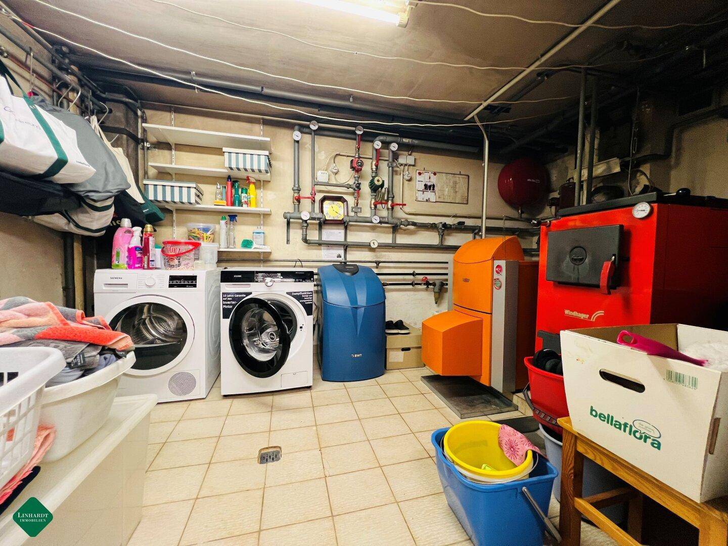 Praktischer Hauswirtschaftsraum im Keller mit Waschmaschinen und Heizungsanlage.