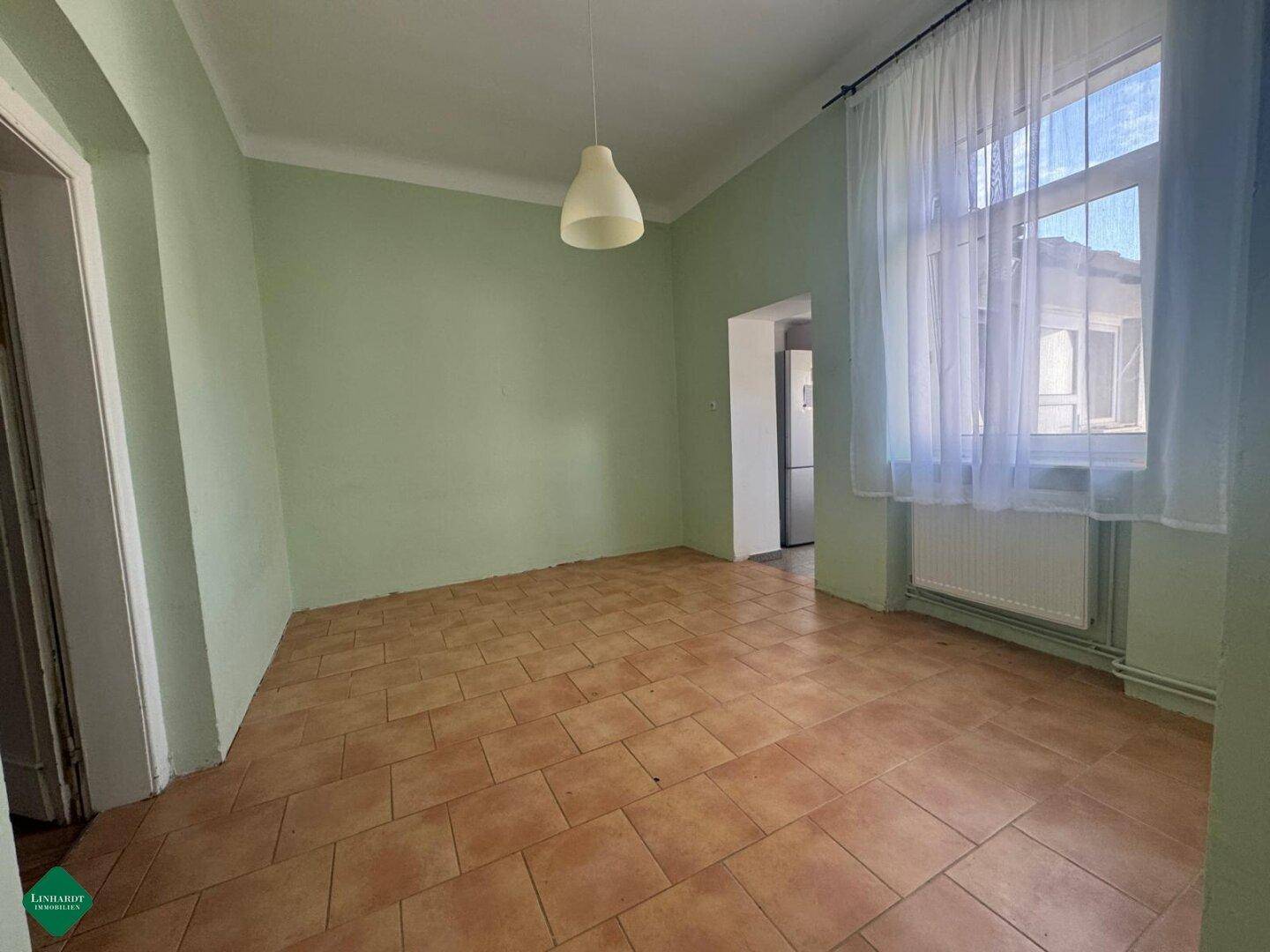 Esszimmer mit hellgrünen Wänden und braunen Fliesen, bereit für eine individuelle Einrichtung.