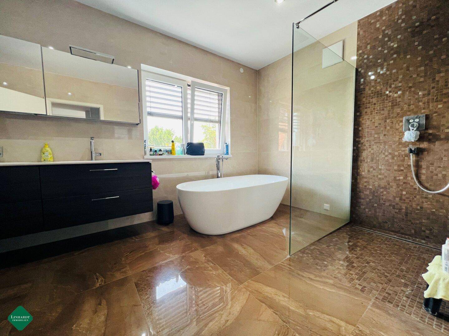 Luxuriöses Badezimmer mit freistehender Badewanne, Doppelwaschbecken und begehbarer Dusche.