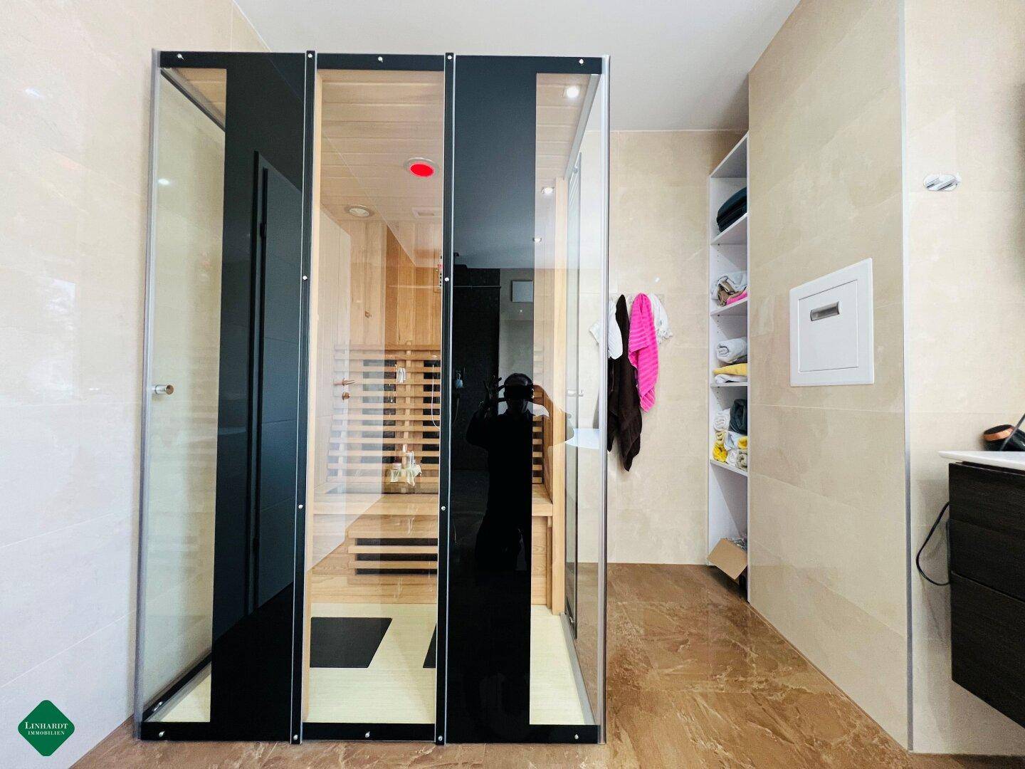 Modernes Badezimmer mit integrierter Sauna und stilvollen Fliesen an den Wänden.