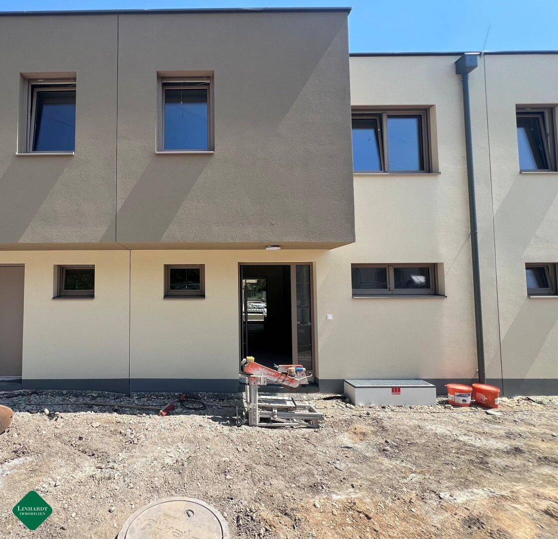Detailansicht der modernen Fassade eines Neubaus mit Eingangsbereich und Fenstern.