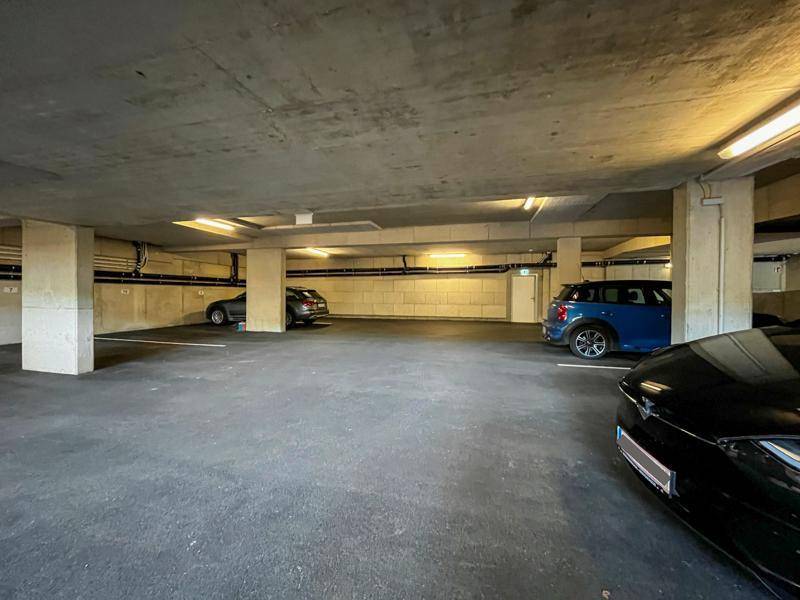Saubere und gut beleuchtete Tiefgarage mit zahlreichen Parkmöglichkeiten für Bewohner.