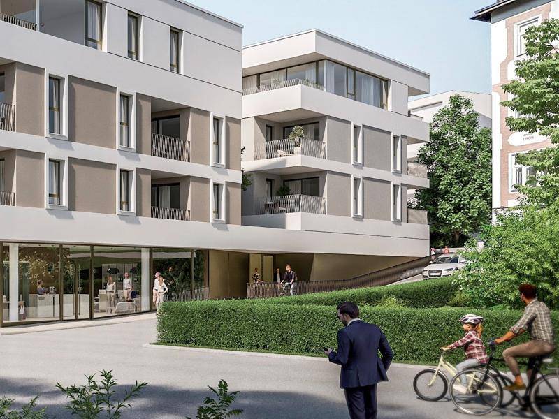 Gesamtansicht der modernen Wohnanlage mit Balkonen, gepflegter Hecke und umliegender Grünfläche.