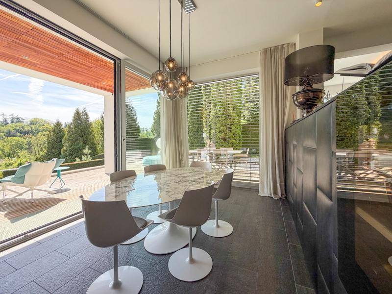 Heller Essbereich mit modernem Esstisch, Designerstühlen und Zugang zur Terrasse.