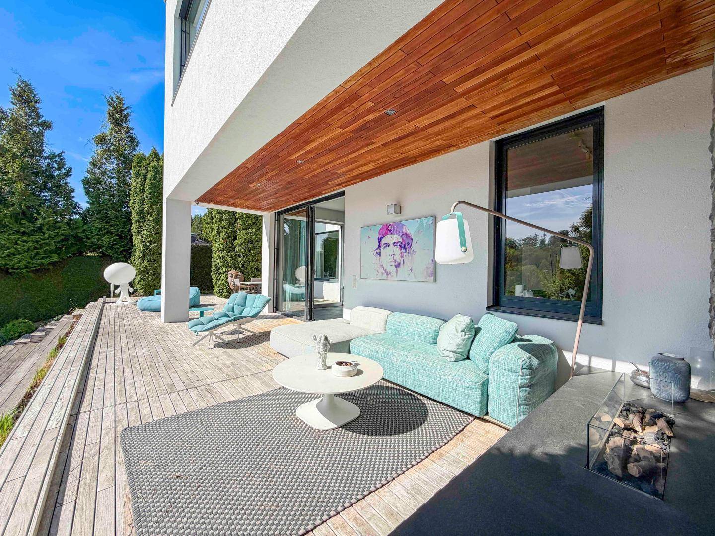 Geräumige Holzterrasse mit modernen Loungemöbeln und direktem Zugang zum Haus.