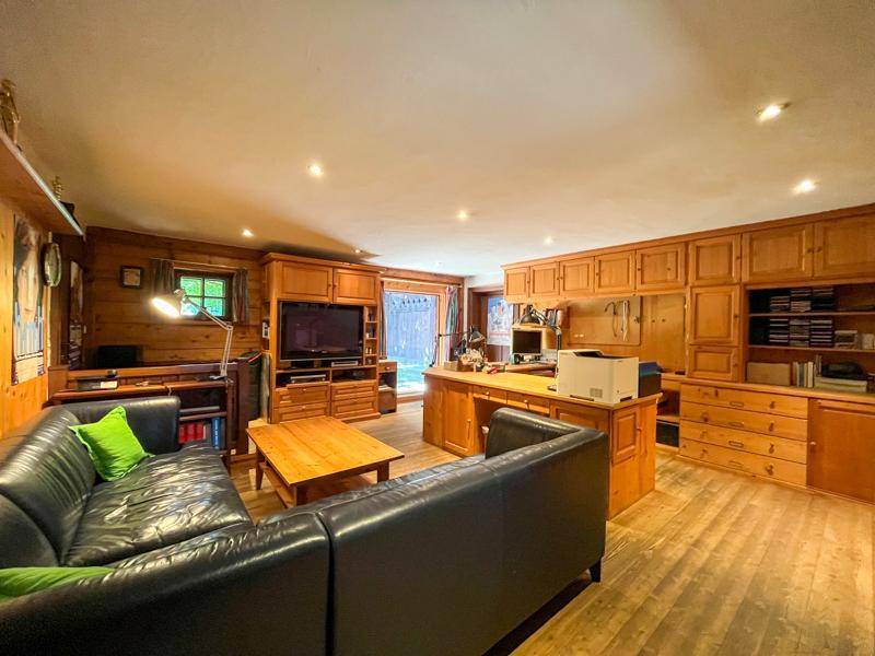 Geräumiges Wohnzimmer mit Holzvertäfelung, Einbauschränken und einem großen Ledersofa.