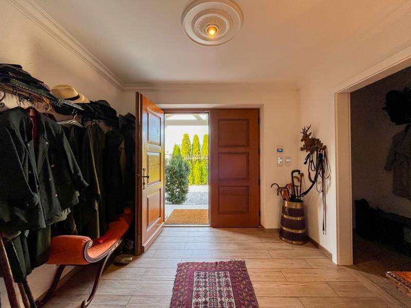 Heller Eingangsbereich mit Holzboden, Garderobe und Blick nach draußen.