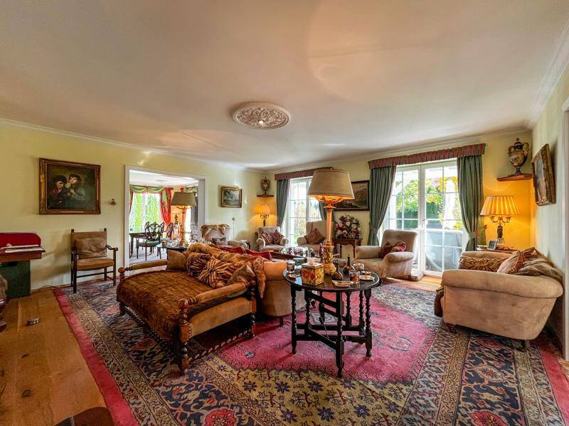 Gemütliches Wohnzimmer mit klassischen Möbeln, Teppich und Blick in den Essbereich.