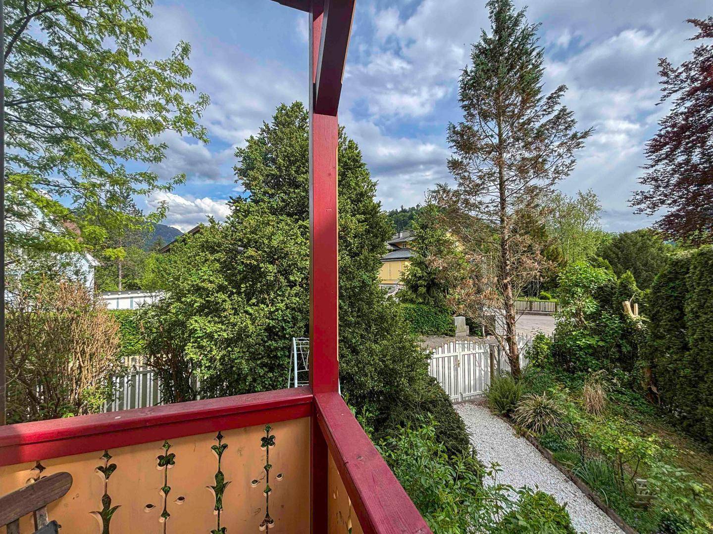 Balkon mit traditionellem Geländer und weitem Blick über die grüne Umgebung.