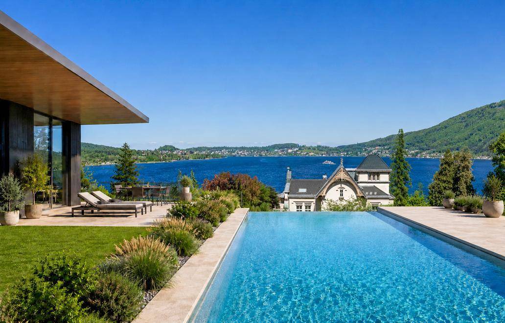 Luxuriöser Infinity-Pool mit Liegeflächen und atemberaubendem Blick auf den See und die Berge.