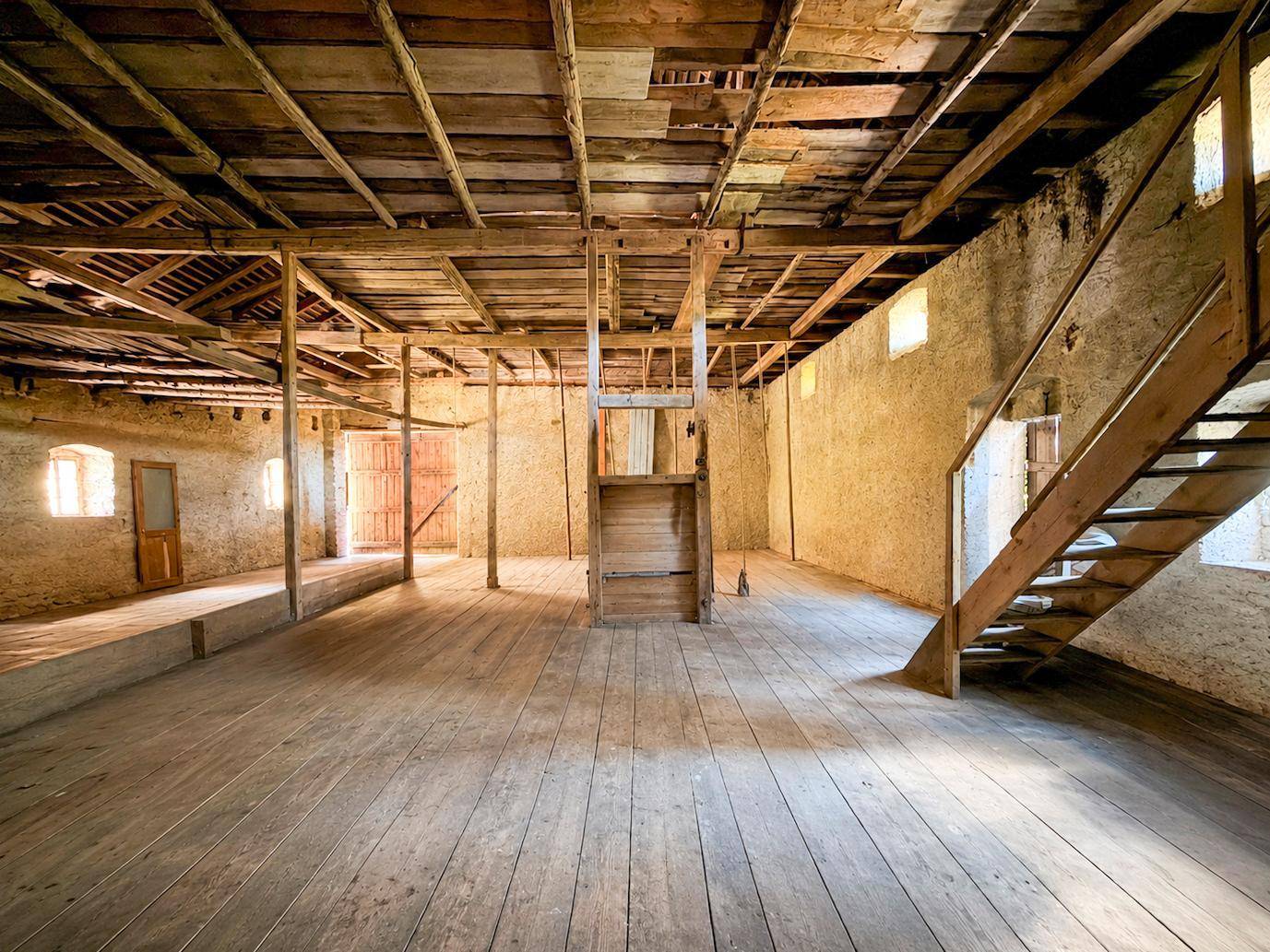 Großer Dachboden mit Holzboden und sichtbaren Balken, ideal für einen Ausbau.