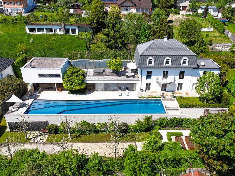 Luftaufnahme des weitläufigen Anwesens mit Hauptgebäude, Pool und großzügiger Gartenanlage.